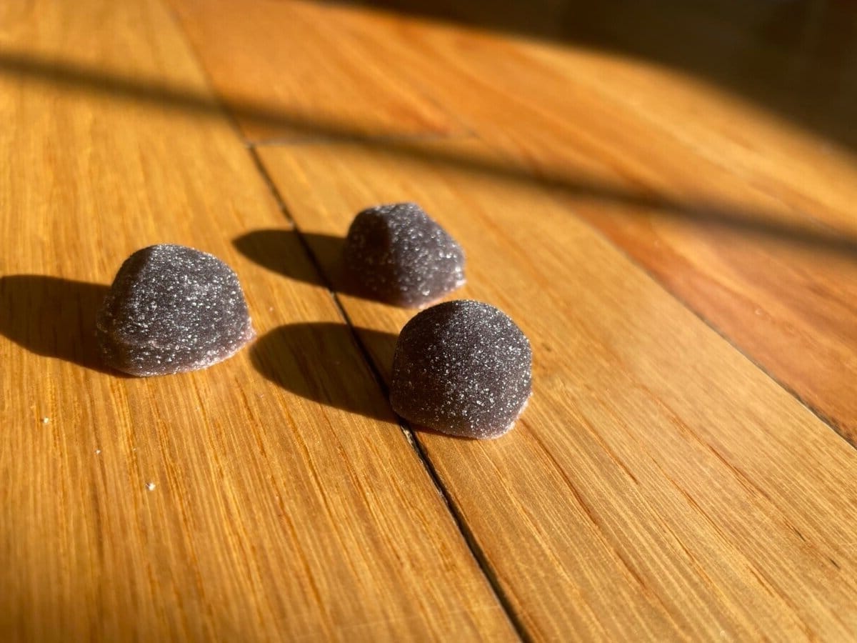 Image of three purple melatonin gummies shown to resemble candy. 