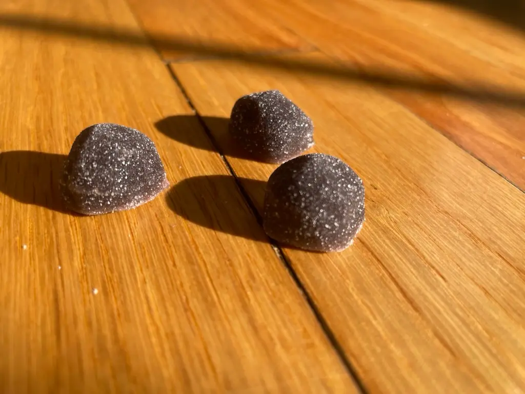 Purple melatonin gummies on a wood floor