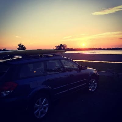 Car with paddleboard at the beach at dawn